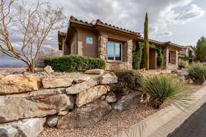 View of front of property featuring stone siding and stucco siding