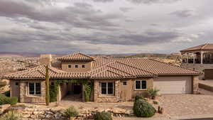 View of front facade featuring stone siding, a garage, decorative driveway, and a chimney