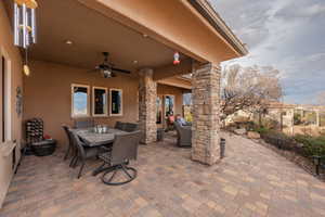 View of patio with outdoor dining area and a ceiling fan