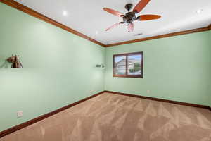 Carpeted empty room with ornamental molding and ceiling fan