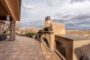 View of patio / terrace featuring exterior fireplace and grilling area