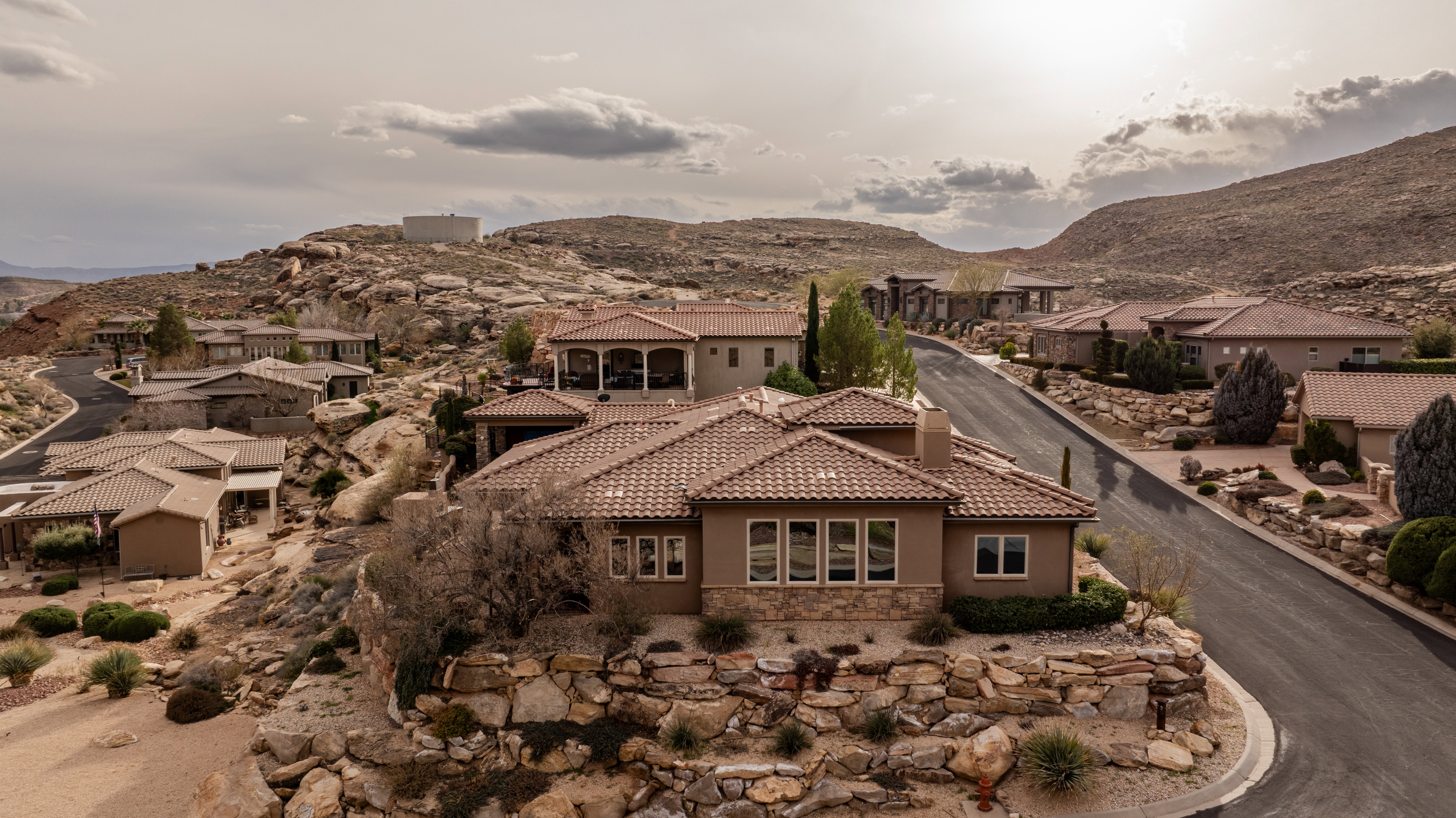 View of front of home featuring a residential view, a mountain view, stucco siding, stone siding, and a tiled roof