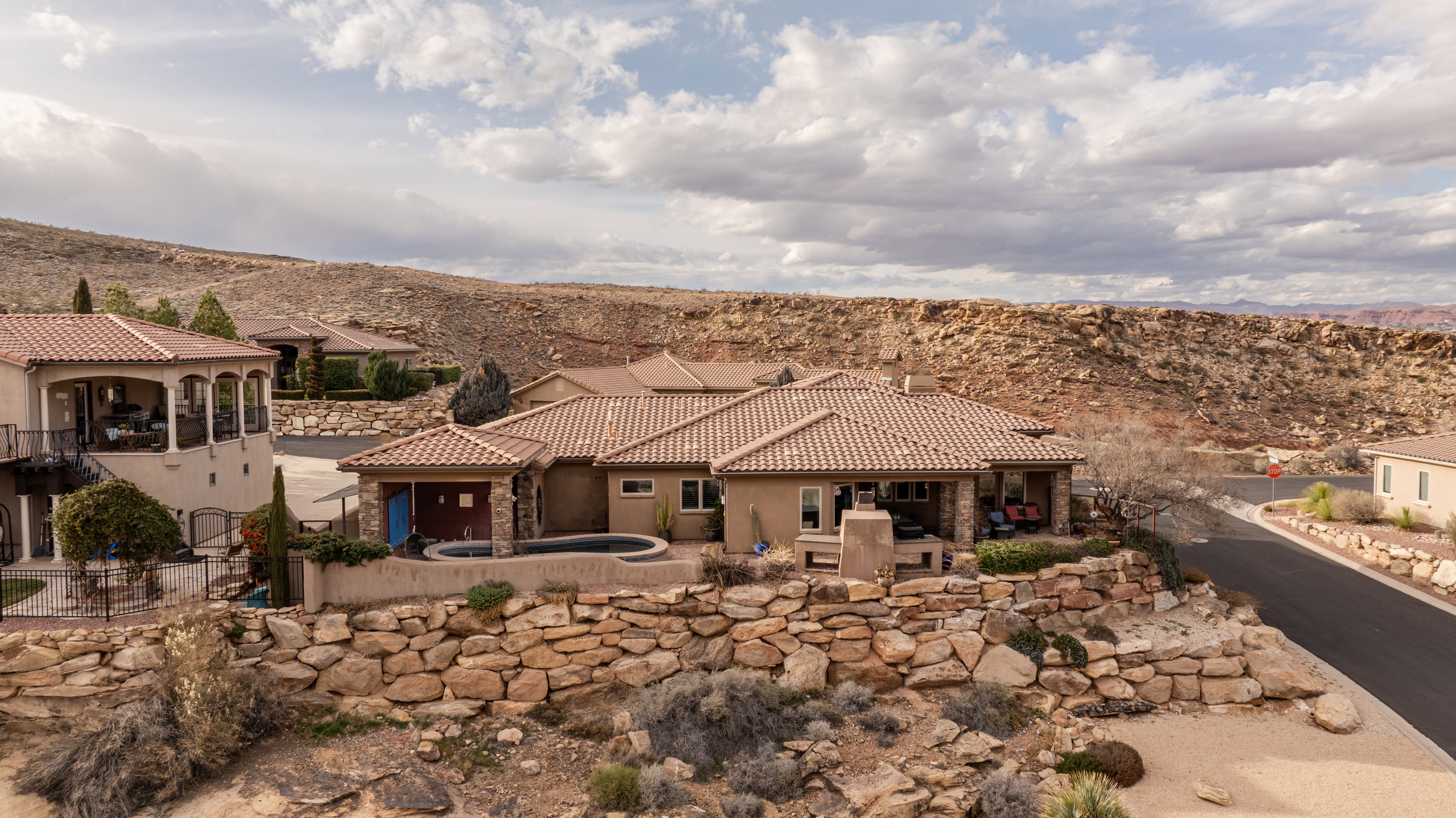 Rear view of property with a patio area, a chimney, stucco siding, and stone siding