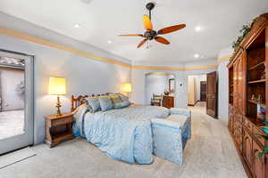 Bedroom with a ceiling fan, light colored carpet, arched walkways, and recessed lighting