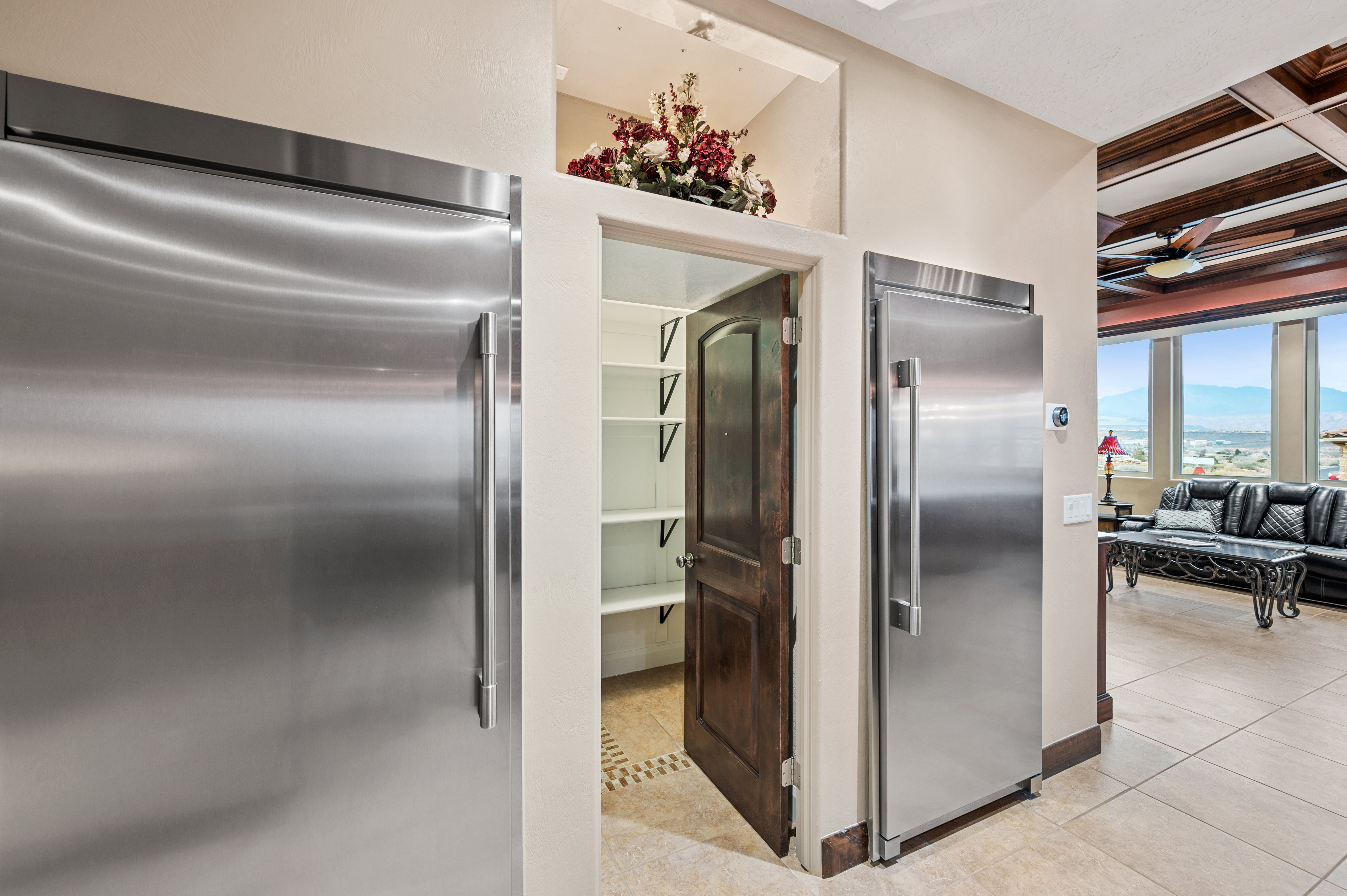 Kitchen with built in refrigerator, coffered ceiling, and a ceiling fan