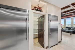 Kitchen with built in refrigerator, coffered ceiling, and a ceiling fan