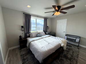 Primary bedroom with ceiling fan, recessed lighting, a water view, and wood finished floors