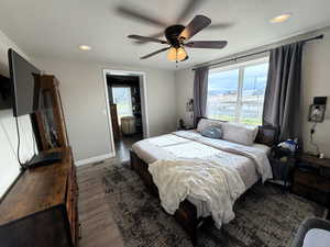 Primary bedroom featuring recessed lighting, wood finished floors, a ceiling fan, and walk in closet