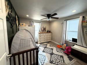 Bedroom with wood finished floors, a ceiling fan, recessed lighting, and a textured ceiling