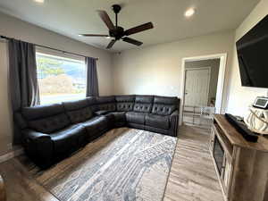 Living area with recessed lighting, light wood finished floors, and a ceiling fan