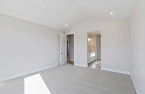 Unfurnished bedroom featuring light carpet, ensuite bath, and recessed lighting