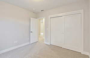 Unfurnished bedroom featuring carpet and a closet