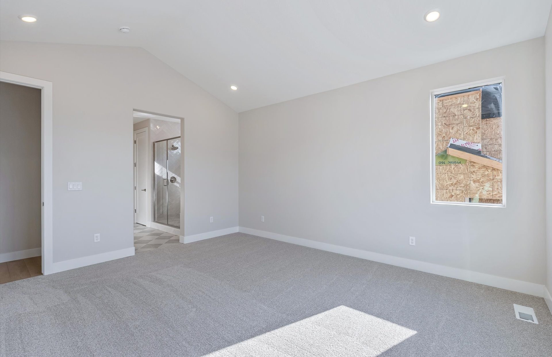 Unfurnished bedroom with vaulted ceiling, light carpet, recessed lighting, and connected bathroom