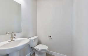Bathroom featuring toilet and baseboards
