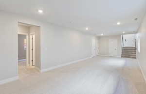 Unfurnished living room with light colored carpet and recessed lighting