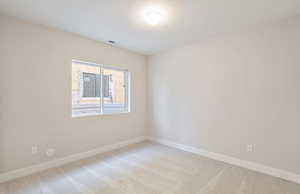 Unfurnished room with light carpet and a textured ceiling