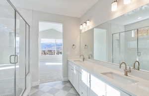 Full bathroom featuring light carpet, a shower stall, double vanity, and healthy amount of natural light