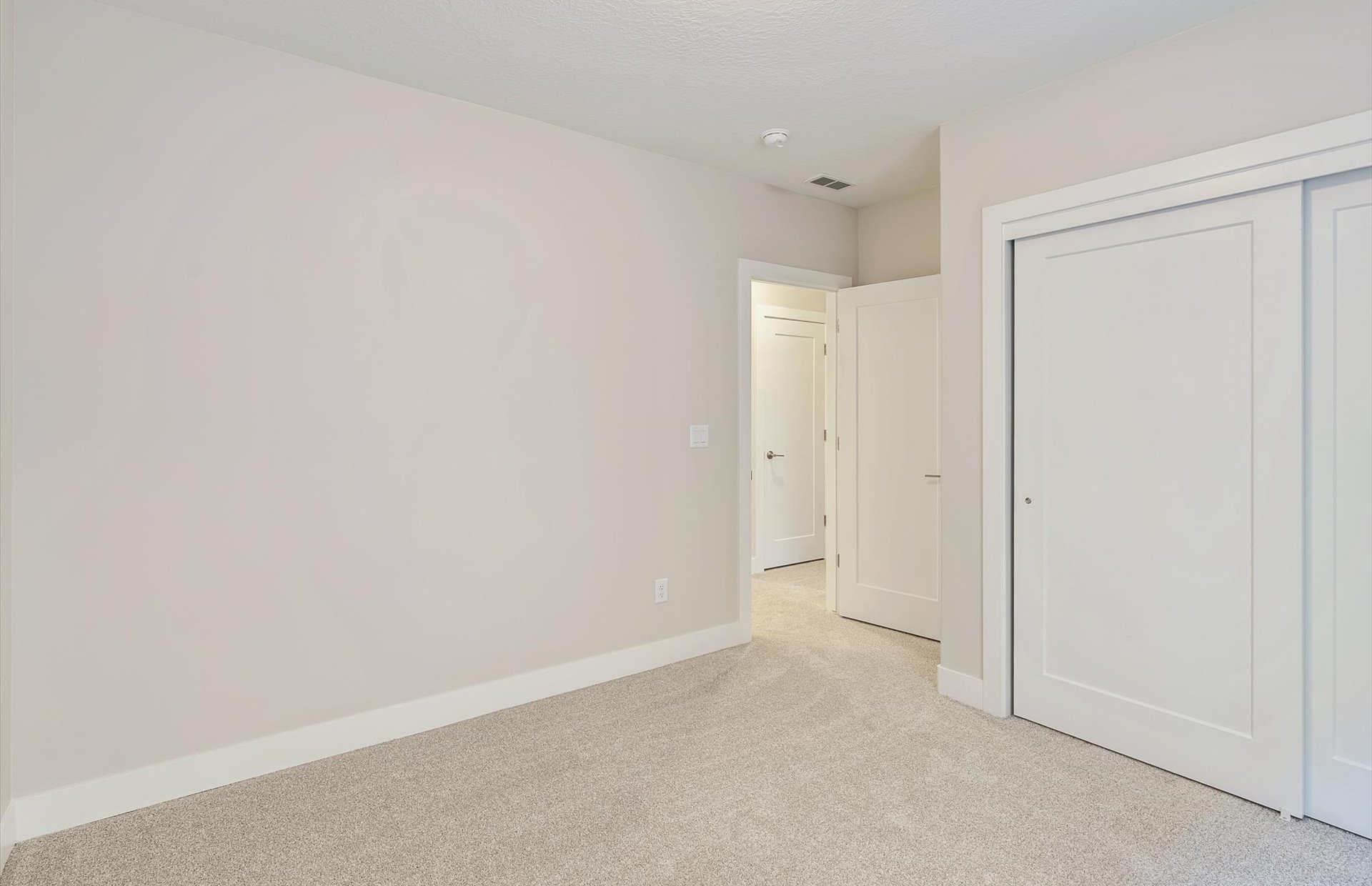 Unfurnished bedroom featuring light carpet and a closet