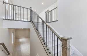 Staircase with a high ceiling, carpet flooring, and recessed lighting
