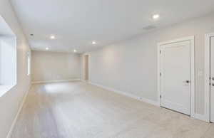 Basement with recessed lighting and light colored carpet
