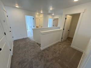 Hallway featuring an upstairs landing and carpet