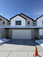 Modern inspired farmhouse with an attached garage and concrete driveway