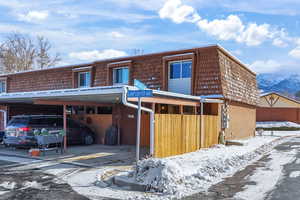 Front facade featuring mansard roof, a mountain view, and a carport