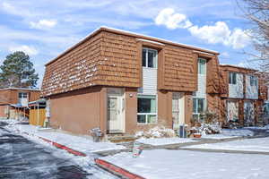 View of front of house featuring brick siding and mansard roof