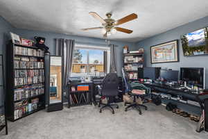 Office with light colored carpet, a textured ceiling, and a ceiling fan