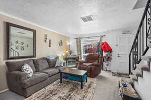Living area featuring light carpet and a textured ceiling