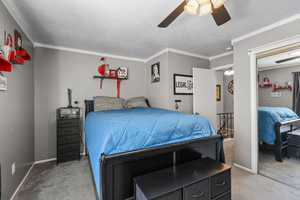 Bedroom featuring carpet flooring, ceiling fan, crown molding, and a textured ceiling