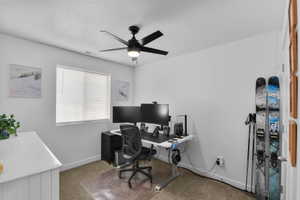 Office area featuring light carpet and ceiling fan