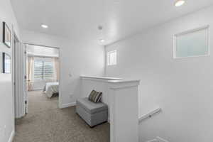 Corridor featuring an upstairs landing, carpet floors, and recessed lighting