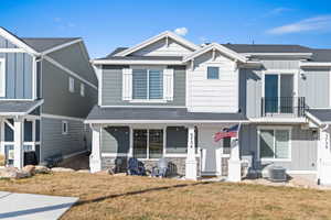 Craftsman-style house featuring board and batten siding, stone siding, and a front yard