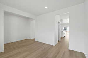 Empty room with light wood-type flooring and recessed lighting