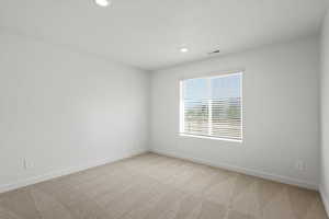 Spare room with light colored carpet and recessed lighting