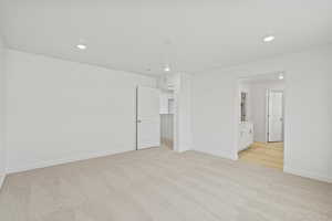 Unfurnished bedroom featuring light carpet, recessed lighting, and connected bathroom