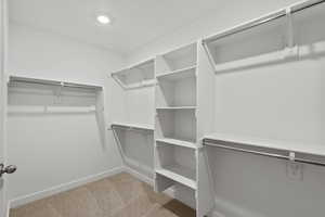 Walk in closet with light carpet