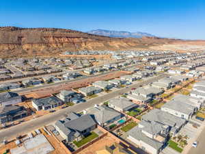 Aerial view of residential area featuring a mountain backdrop and backyard with pool area