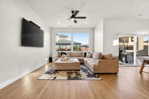 Living room with ceiling fan, light wood finished floors, and recessed lighting