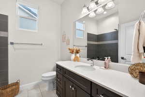 Full bathroom featuring vanity, light tile patterned floors, and a tile shower