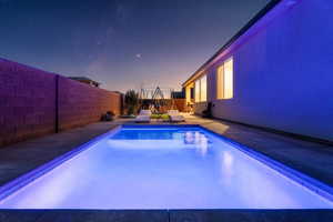 View of swimming pool with a fenced backyard, a trampoline, and patio surround