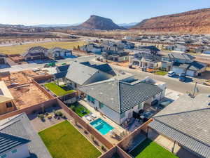 Aerial view of residential area featuring a mountain backdrop and backyard with pool area