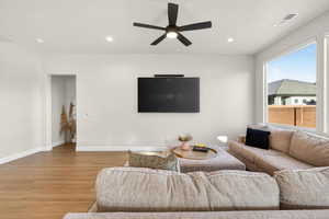 Living area with a ceiling fan, light wood-style floors, and recessed lighting