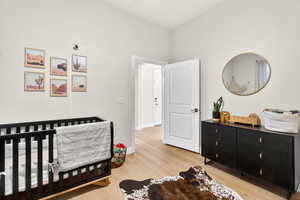 Bedroom featuring a crib and light wood-type flooring
