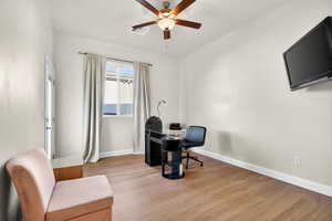 Casita bedroom or office with additional private entrance featuring light wood-style flooring and a ceiling fan