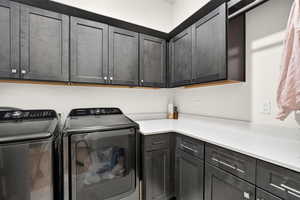 Laundry area featuring washer and clothes dryer and cabinet space