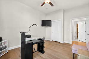 Casita bedroom or office with additional private entrance featuring light wood-style flooring and a ceiling fan