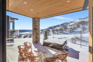 Snow covered patio with a mountain view