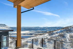Snow covered back of property featuring a mountain view